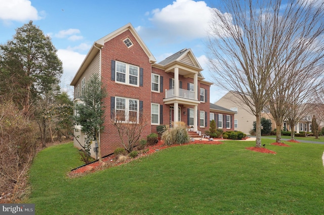 view of front of house featuring a balcony and a front lawn