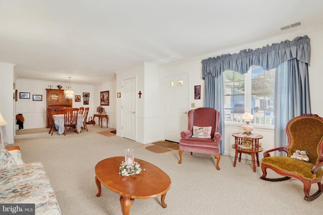 carpeted living room featuring crown molding and a chandelier