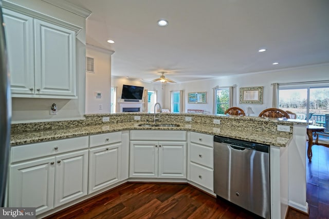 kitchen featuring sink, white cabinets, dark hardwood / wood-style flooring, stainless steel dishwasher, and kitchen peninsula