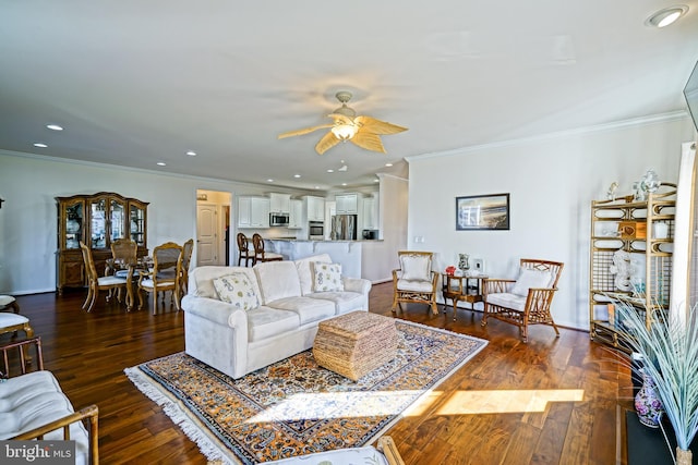 living room featuring ceiling fan, ornamental molding, and dark hardwood / wood-style flooring