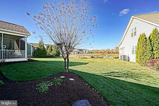 view of yard with central AC and a water view