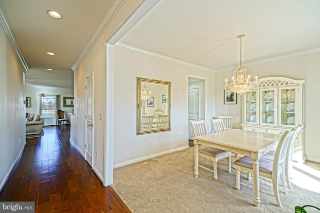 dining room featuring an inviting chandelier, crown molding, and dark hardwood / wood-style floors