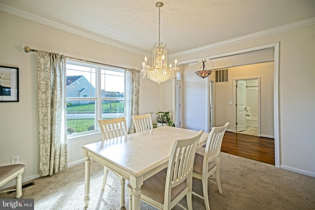 carpeted dining space featuring crown molding