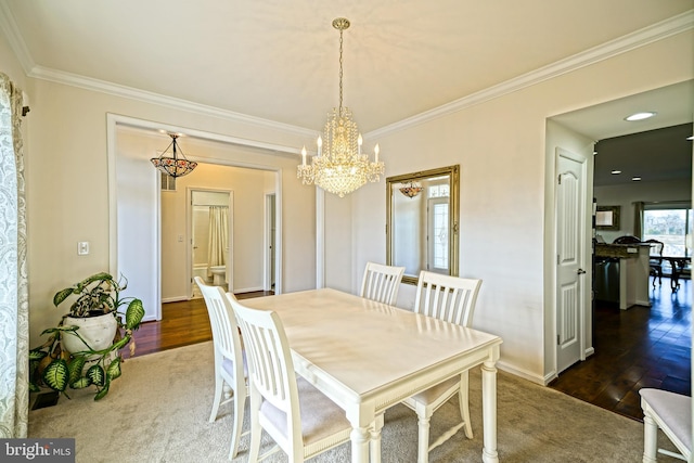 dining space with dark wood-type flooring, crown molding, and an inviting chandelier