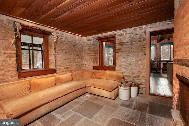 unfurnished living room with a healthy amount of sunlight, wooden ceiling, and a baseboard heating unit