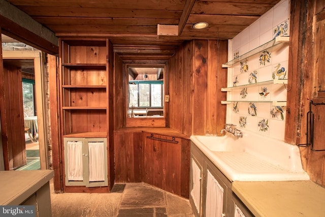 interior space with sink, wooden walls, a healthy amount of sunlight, and wood ceiling