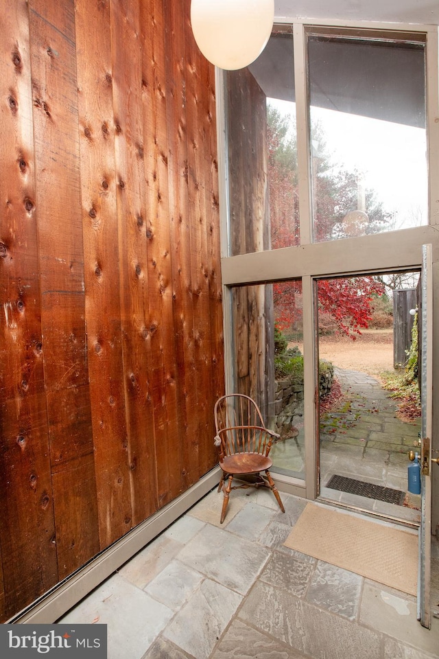 unfurnished sunroom featuring a wealth of natural light and a baseboard heating unit