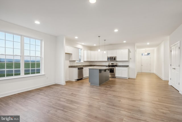 kitchen featuring pendant lighting, white cabinetry, a center island, and stainless steel appliances