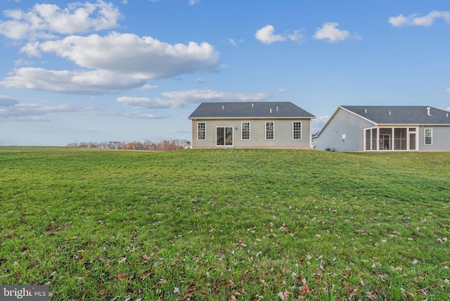 back of house with a lawn and a sunroom