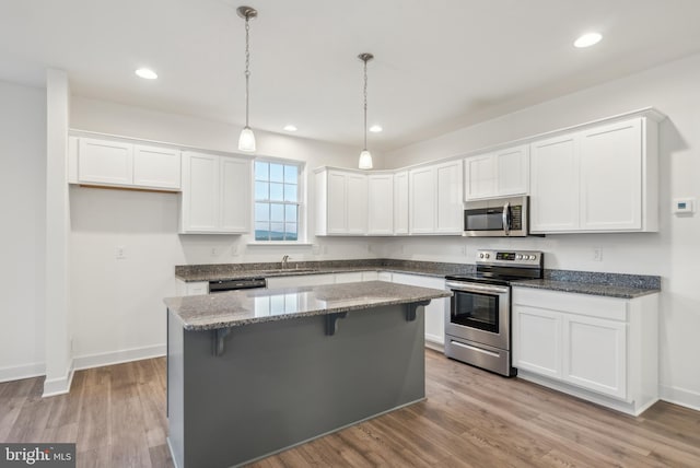 kitchen with white cabinetry, stainless steel appliances, and light hardwood / wood-style flooring