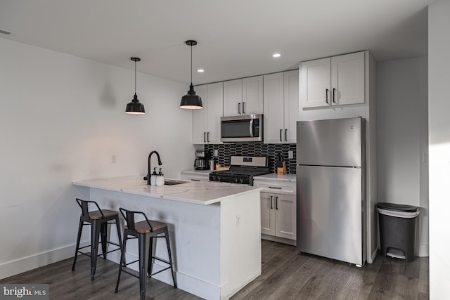 kitchen featuring kitchen peninsula, white cabinetry, sink, and stainless steel appliances