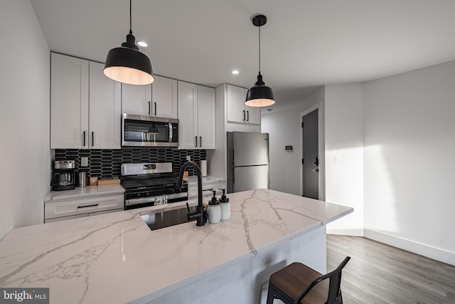 kitchen with light stone countertops, decorative backsplash, stainless steel appliances, and sink