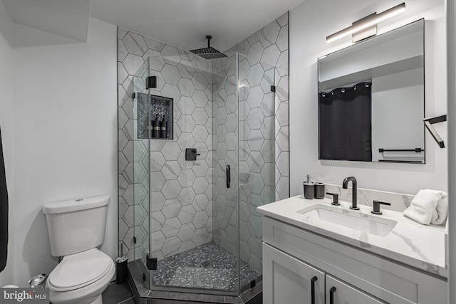 bathroom with vanity, toilet, and a shower with shower door