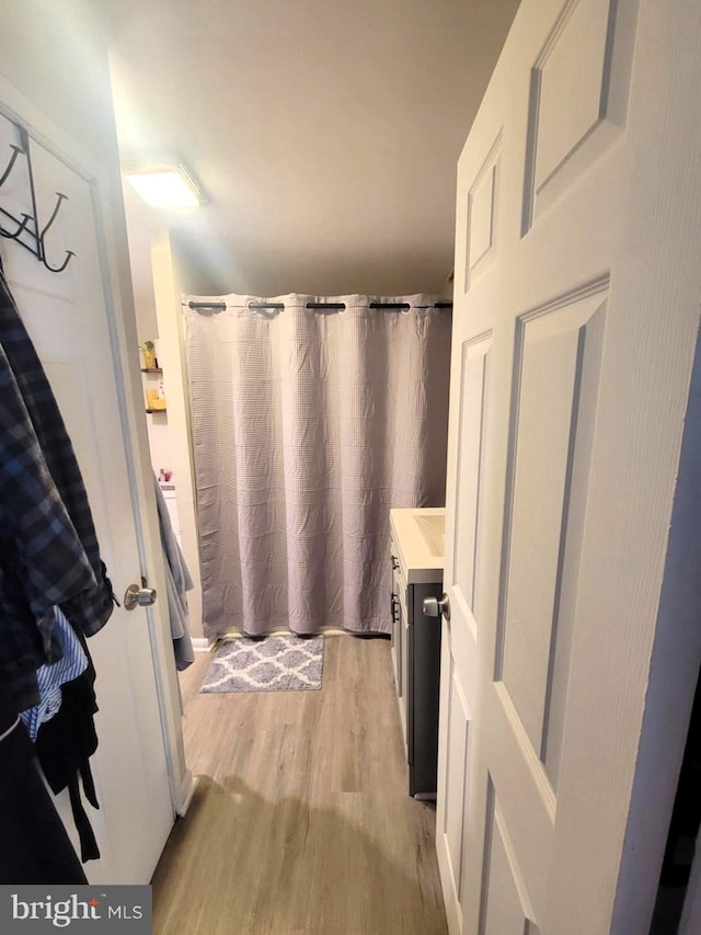 bathroom with curtained shower, hardwood / wood-style floors, and vanity