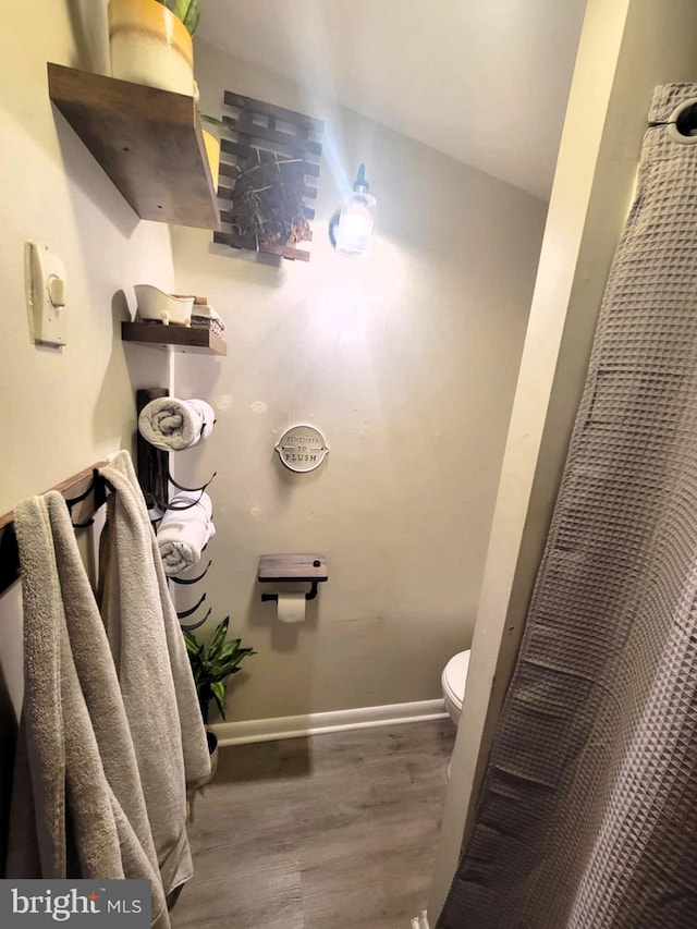 bathroom featuring hardwood / wood-style floors and toilet