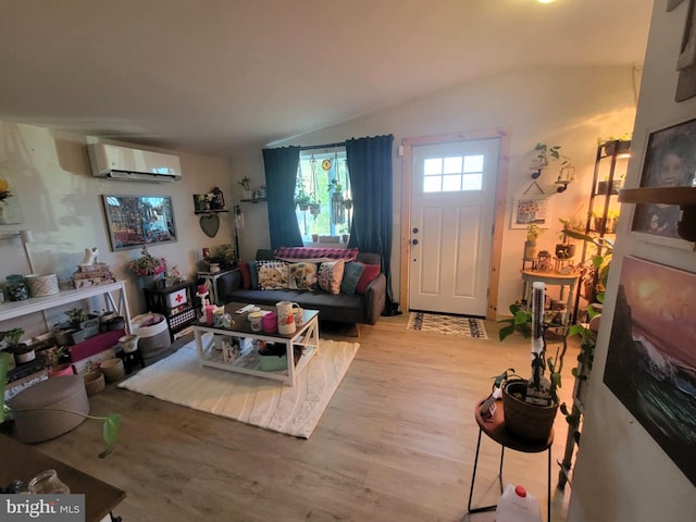 living room featuring hardwood / wood-style flooring, lofted ceiling, and a wall mounted AC