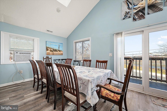 dining room with dark hardwood / wood-style floors, high vaulted ceiling, and cooling unit