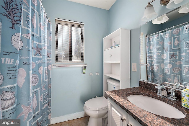 bathroom with tile patterned flooring, vanity, and toilet