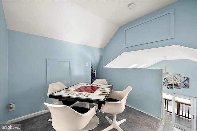 dining area featuring dark carpet and lofted ceiling