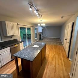 kitchen featuring dishwasher, track lighting, white cabinets, and light hardwood / wood-style flooring