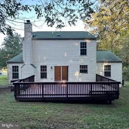 back of property featuring a deck and a yard