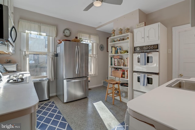 kitchen featuring ceiling fan, white cabinets, and appliances with stainless steel finishes