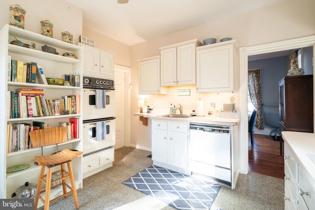 kitchen with white appliances, light hardwood / wood-style floors, white cabinetry, and sink