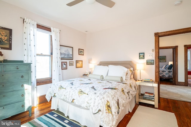 bedroom with dark hardwood / wood-style flooring and ceiling fan