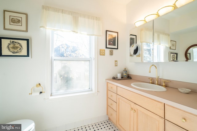 bathroom featuring tile patterned floors, vanity, a healthy amount of sunlight, and toilet