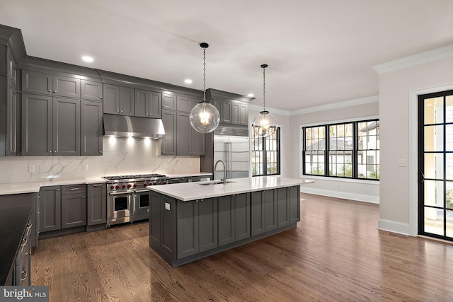 kitchen featuring gray cabinetry, high end appliances, hanging light fixtures, dark hardwood / wood-style floors, and an island with sink