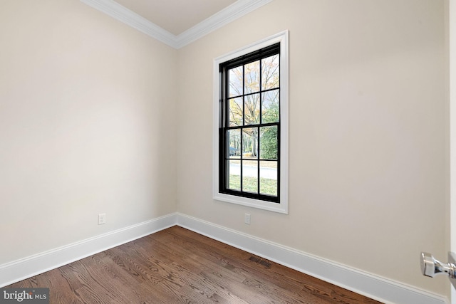 empty room featuring hardwood / wood-style floors and ornamental molding