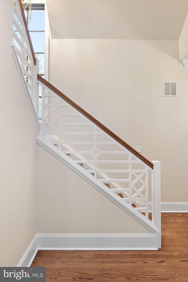 staircase with hardwood / wood-style flooring