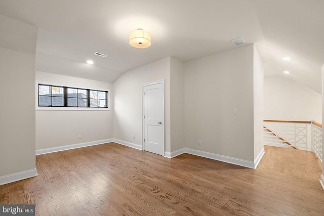 unfurnished room featuring hardwood / wood-style floors and lofted ceiling