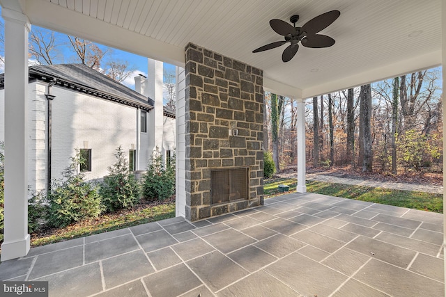 view of patio / terrace with an outdoor stone fireplace and ceiling fan