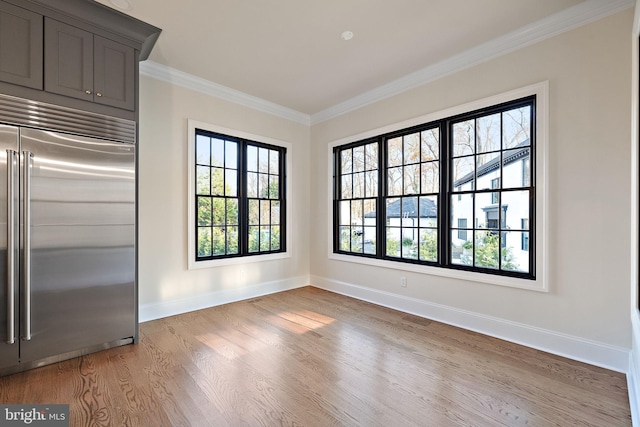 unfurnished dining area with crown molding and light wood-type flooring