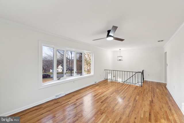 unfurnished room with crown molding, light hardwood / wood-style floors, and ceiling fan with notable chandelier