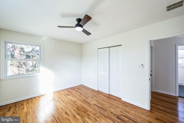 unfurnished bedroom featuring a closet, hardwood / wood-style flooring, and ceiling fan