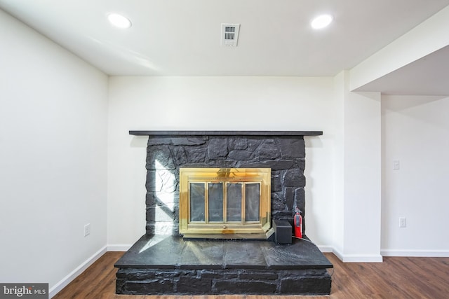 room details featuring hardwood / wood-style floors and a stone fireplace