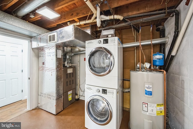 laundry room featuring stacked washer and clothes dryer, heating unit, and water heater