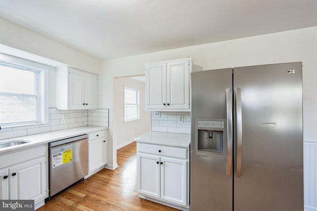 kitchen featuring white cabinets, light hardwood / wood-style floors, and appliances with stainless steel finishes