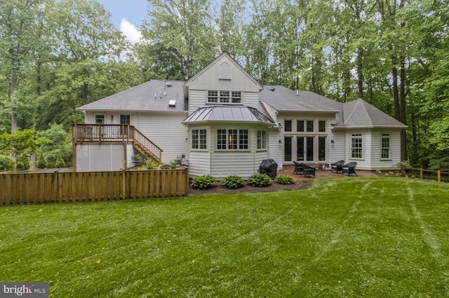 rear view of property with a yard, a deck, and a patio area