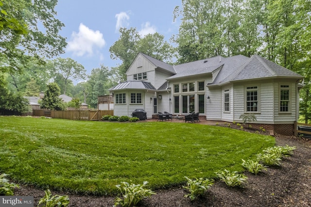 rear view of property featuring a patio and a yard