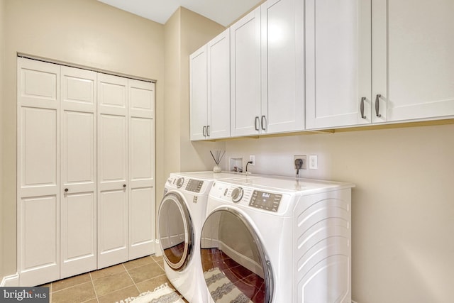 laundry area featuring cabinets, washing machine and clothes dryer, and light tile patterned floors