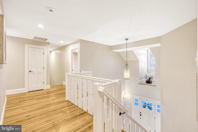 hallway with lofted ceiling and light hardwood / wood-style floors