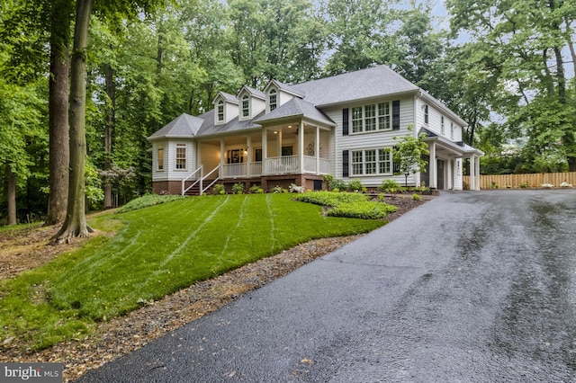 view of front of home with a front yard, covered porch, and a garage