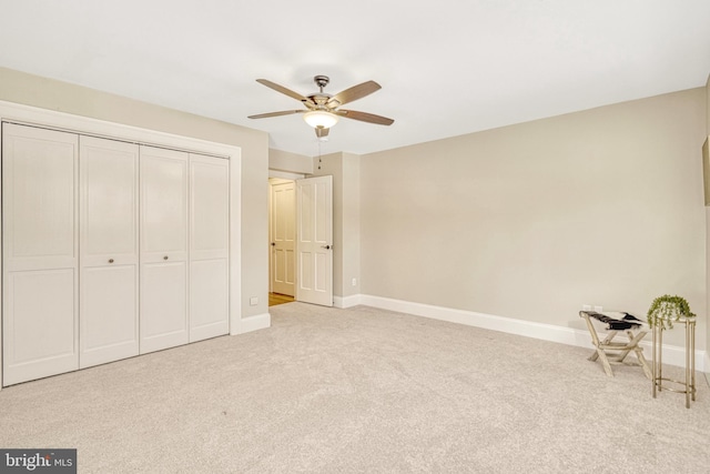 unfurnished bedroom featuring a closet, ceiling fan, and light colored carpet