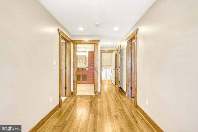 hall with light hardwood / wood-style floors and sink