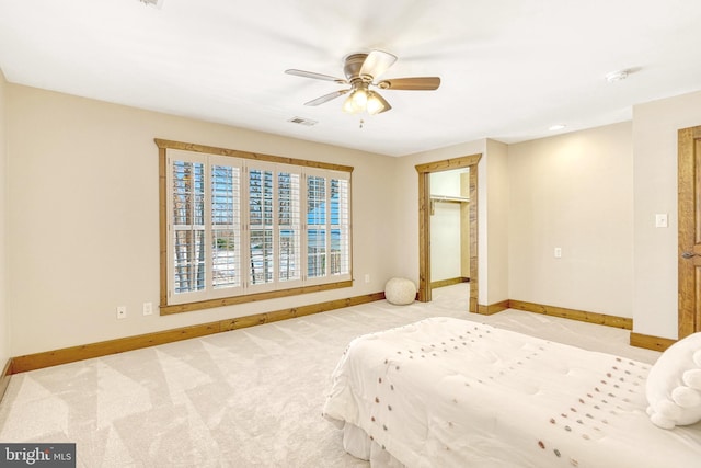 unfurnished bedroom featuring ceiling fan, a walk in closet, a closet, and light colored carpet