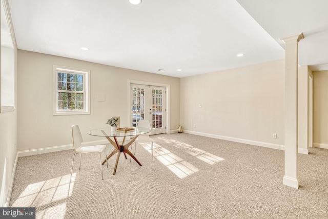 unfurnished dining area with decorative columns, light colored carpet, and french doors