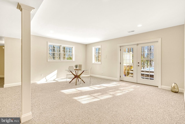 carpeted spare room featuring french doors and a wealth of natural light